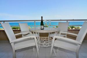 a table with a bottle of wine and chairs on a balcony at New! Fantastic apartament in front of the sea! in Pineda de Mar
