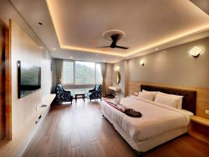 Pokój hotelowy z łóżkiem, biurkiem i telewizorem w obiekcie Avianna Gangtok Resort & Spa w mieście Bhurtuk