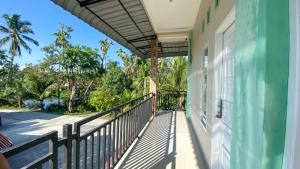 a balcony of a house with a fence and trees at Penginapan Malompek Syariah in Duku