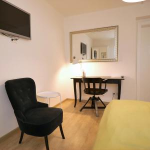 グラーツにあるHotel Villa Rückertのデスク、椅子、鏡が備わる客室です。