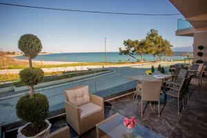 patio ze stołem i krzesłami oraz oceanem w obiekcie Kavala Resort & Spa w mieście Nea Karvali