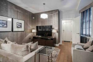 a living room with a couch and a tv at Covent Garden / Trafalgar / Leicester Sq Diamond in London