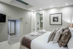 a bedroom with a large white bed with pillows at Covent Garden / Trafalgar / Leicester Sq Diamond in London