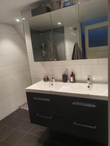a bathroom with a sink and a mirror at Modern loftsleilighet in Fredrikstad