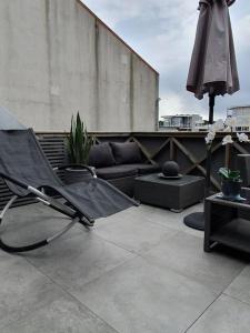 una silla vacía y una sombrilla en un patio en Modern loftsleilighet, en Fredrikstad