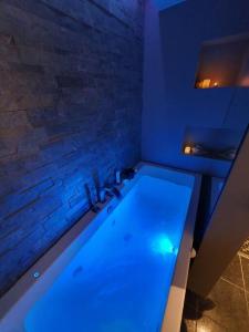 un bagno con una grande vasca con illuminazione blu di Modern loftsleilighet a Fredrikstad
