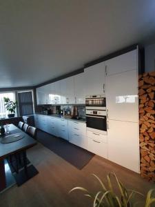 a kitchen with white cabinets and a table in it at Modern loftsleilighet in Fredrikstad
