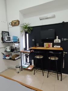 uma cozinha com uma mesa e dois bancos num quarto em Monoambiente Villa Crespo em Buenos Aires