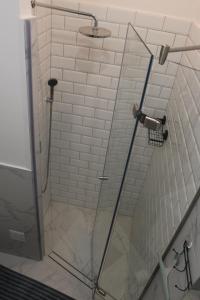 y baño con ducha y puerta de cristal. en Larix apartman, en Budapest