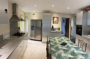 a kitchen with a table and a stainless steel refrigerator at maison casa nova in Biguglia