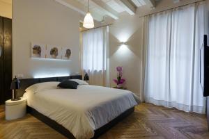 1 dormitorio con 1 cama grande y cortinas blancas en IL CANTUN en Monforte dʼAlba