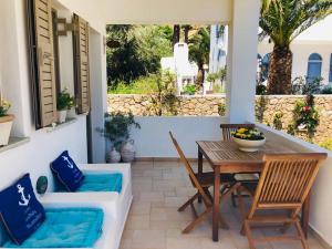 eine Terrasse mit einem Holztisch und Stühlen sowie einem Tisch und Stühlen in der Unterkunft La Bastide in Skyros