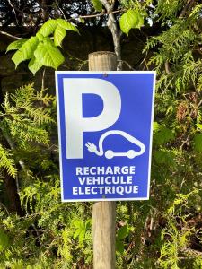 a blue parking sign on a wooden pole at Logis Hostellerie la Chaumière in Arsonval