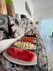 a buffet with several plates of food on a table at Pousada Serrate in Ubatuba