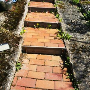 Una pasarela de ladrillo con algunas plantas. en Ferienhaus mit riesen Garten, drei Terrassen, toller Aussicht am Waldrand, auch als Monteur-Wohnung en Hemer