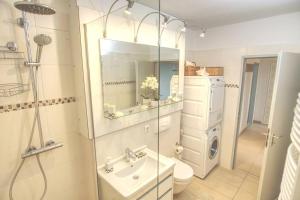 a bathroom with a sink and a washing machine at Ferienwohnung mit herrlichem Ausblick meerwärts in Wilhelmshaven +4 photos