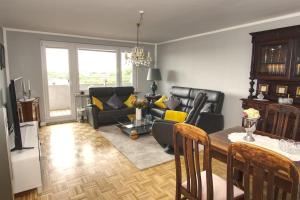 a living room with a table and a couch at Ferienwohnung mit herrlichem Ausblick meerwärts in Wilhelmshaven