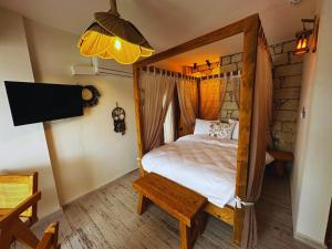 a bedroom with a canopy bed and a tv at Fizzio Alaçatı Hotel in Alaçatı +139 photos