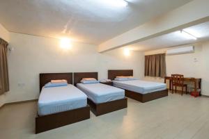 um quarto com 2 camas, uma mesa e uma secretária em clp perai homstay near Sri Muniswarar Temple em Perai