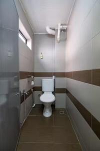 uma casa de banho com um WC branco numa cabina em clp perai homstay near Sri Muniswarar Temple em Perai