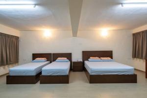 a room with two beds and two night stands at clp perai homstay near Sri Muniswarar Temple in Perai