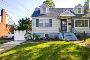 a house with a white fence and a yard at Quaint Forest Heights Escape about 9 Mi to Downtown DC 