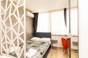 a small room with a bed and a chair at Valaoritou Luxury Studio in Thessaloniki
