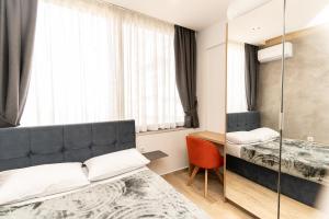 a hotel room with two beds and a mirror at Valaoritou Luxury Studio in Thessaloniki