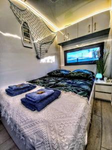 een slaapkamer met een bed met handdoeken erop bij ARKA 2 - Houseboat w centrum Mielna, rower wodny, parking, Wi-Fi in Mielno