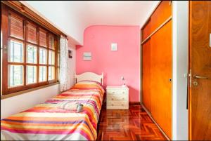 a bedroom with two beds in a room with pink walls at Experiencia Olivos in Florida +16 photos
