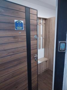 una porta in legno con un cartello in bagno di Apartman 007 a Kragujevac