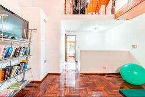 a living room with a wooden floor and a book shelf at Experiencia Olivos in Florida