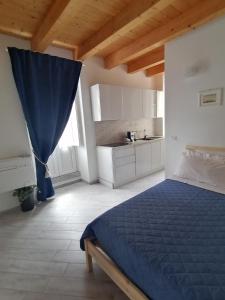 1 dormitorio con 1 cama azul y cocina en Domus plano de laczarulo Acciaroli, en Acciaroli