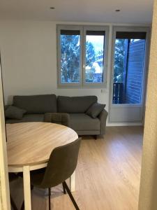 uma sala de estar com um sofá e uma mesa em Duplex Aiguille du Midi furnished flat em Chamonix-Mont-Blanc