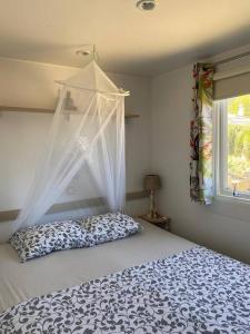 ein Schlafzimmer mit einem Himmelbett und einem Fenster in der Unterkunft Cozy cottage in nature, with Garden and Sea View & Fast 350mbps Wi-Fi in Tarifa