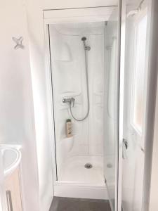 a white bathroom with a shower and a sink at Cozy cottage in nature, with Garden and Sea View & Fast 350mbps Wi-Fi in Tarifa