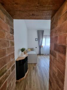 uma sala de estar com uma parede de tijolos e uma mesa em DA LAURA em Bottidda