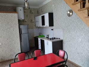 a kitchen with a red table and chairs in it at Natali & Giga in Ureki +19 photos