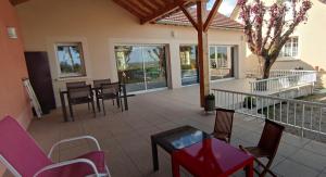 eine Terrasse mit Stühlen und Tischen auf dem Balkon in der Unterkunft La Petite Maison in Givry