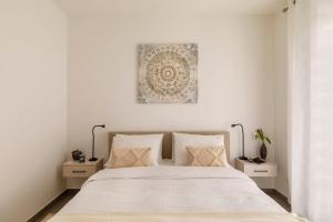 a white bedroom with a large bed with white sheets at Lugano Superior Suites - Free Parking in Lugano