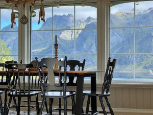 a dining room table and chairs with a view of mountains at Sundet Lofoten Holiday House in Sund