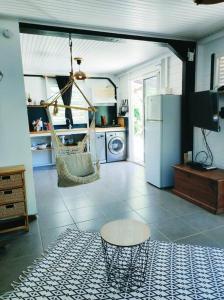 a living room with a hammock and a kitchen at L'Eucalyptus in La Trinité