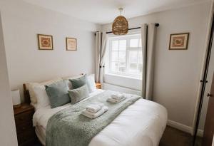 1 dormitorio con 1 cama con toallas en CLIFFE COTTAGE - Countryside Cottage in Castleton, Peak District National Park, en Castleton