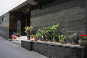 un bâtiment avec des plantes en pot à l'avant dans l'établissement Daeyoung Hotel Myeongdong, à Séoul