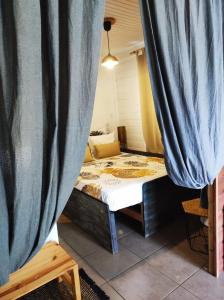 Zimmer mit einem Bett und einem Vorhang in der Unterkunft L'Eucalyptus in La Trinité