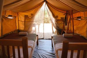sypialnia z 2 łóżkami w namiocie w obiekcie Kara-Tunga Safari Camp w mieście Moroto