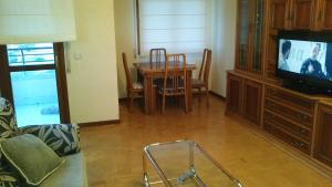 uma sala de estar com uma mesa e uma televisão em Piso céntrico y luminoso em Vitoria-Gasteiz