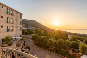 einen Blick auf den Sonnenuntergang vom Balkon eines Gebäudes in der Unterkunft Hotel Brancamaria in Cala Gonone