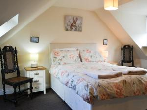 a bedroom with a bed and a chair at Cygnet Cottage - Uk43546 in Belford