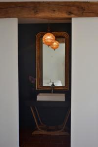 bagno con specchio e lavandino di Chambre d'hôte au Domaine Terre de Chênes a Saint-Paul-de-Baïse